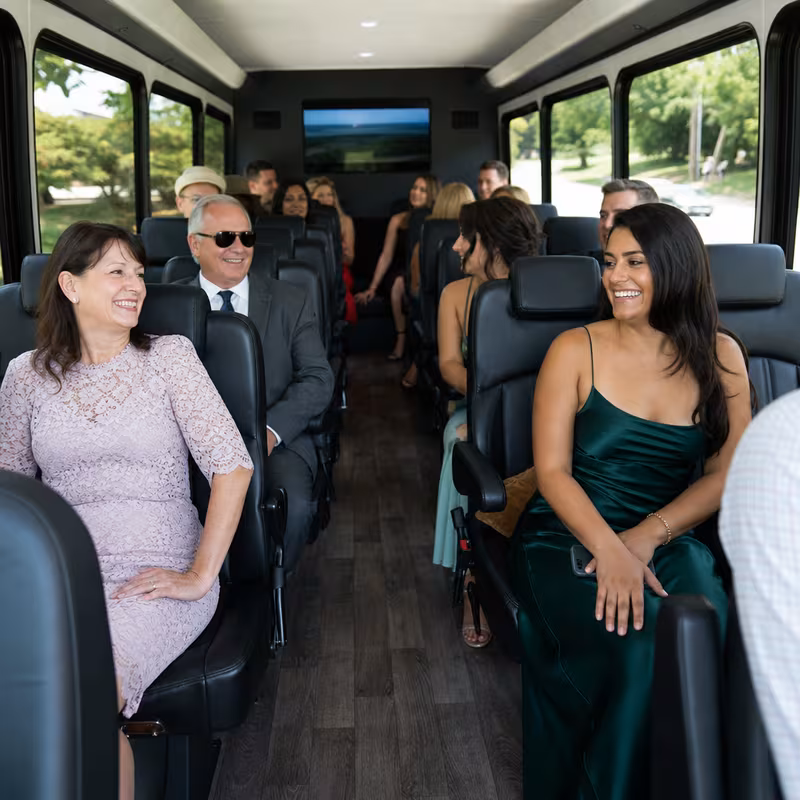 Group boarding a white charter bus for Private Event Transportation transportation in Tallahassee